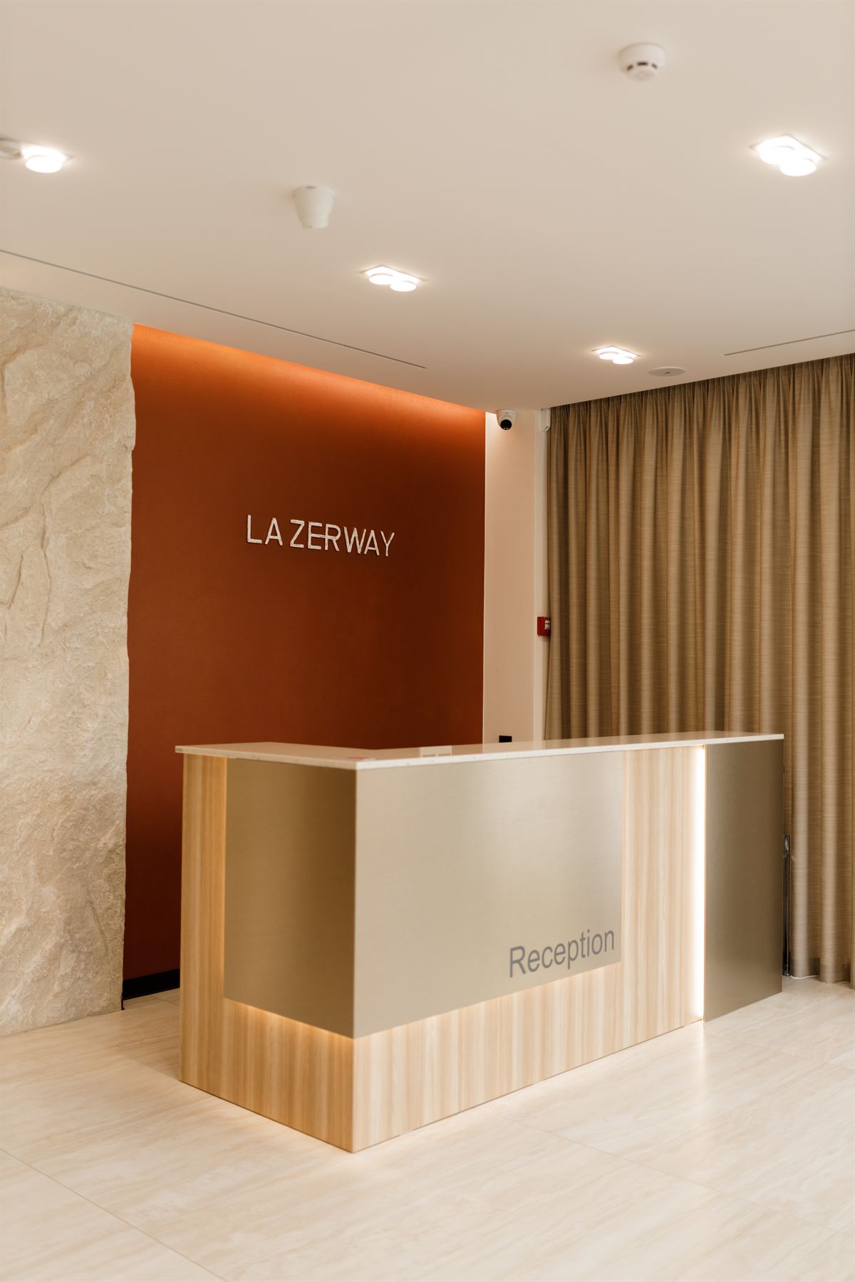 Ресепшн клініки La Zerway у Львові: фірмова теракотова стіна з написом LA ZERWAY