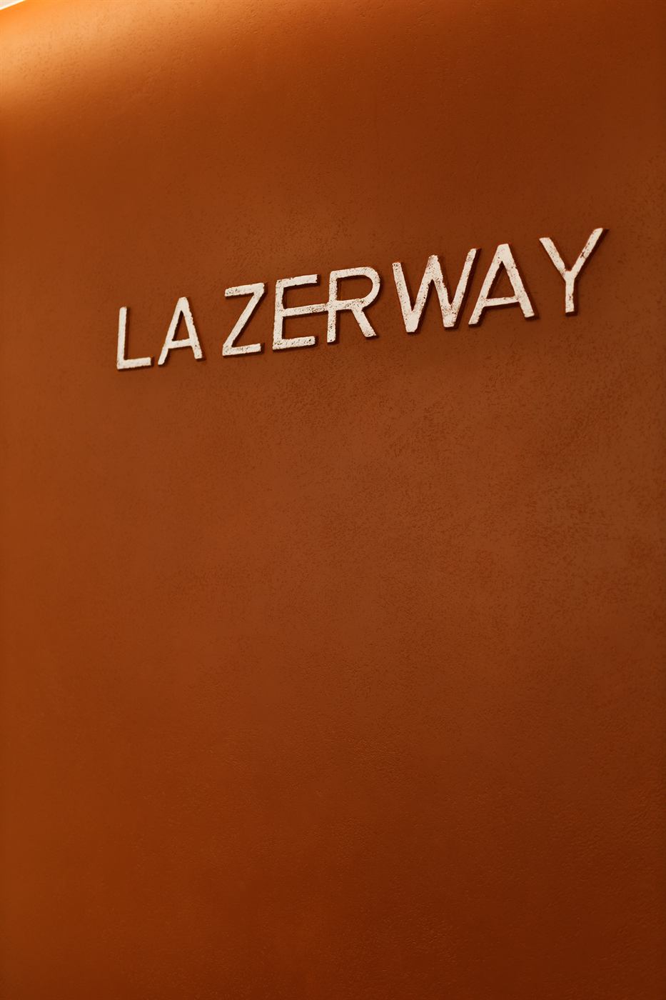 Фірмове панно La Zerway з логотипом на теракотовій стіні клініки